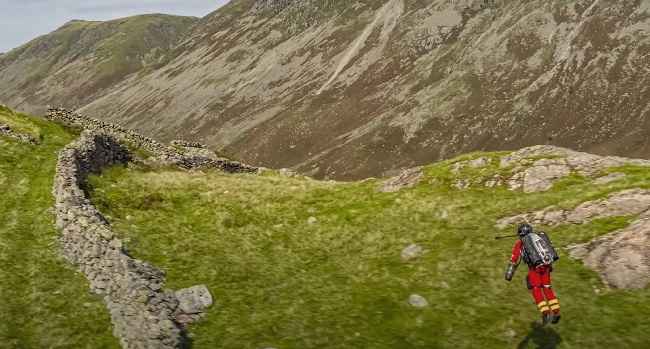 Jetpack paramedic gliding across a mountain